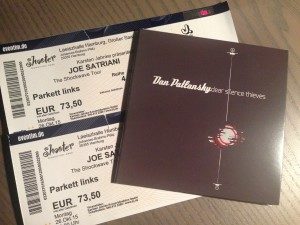 Die Erinnerungsstücke eines wunderbaren Abends: Konzertkarten von Joe Satriani und das aktuelle Album „Dear Silence Thieves“ von Dan Patlansky